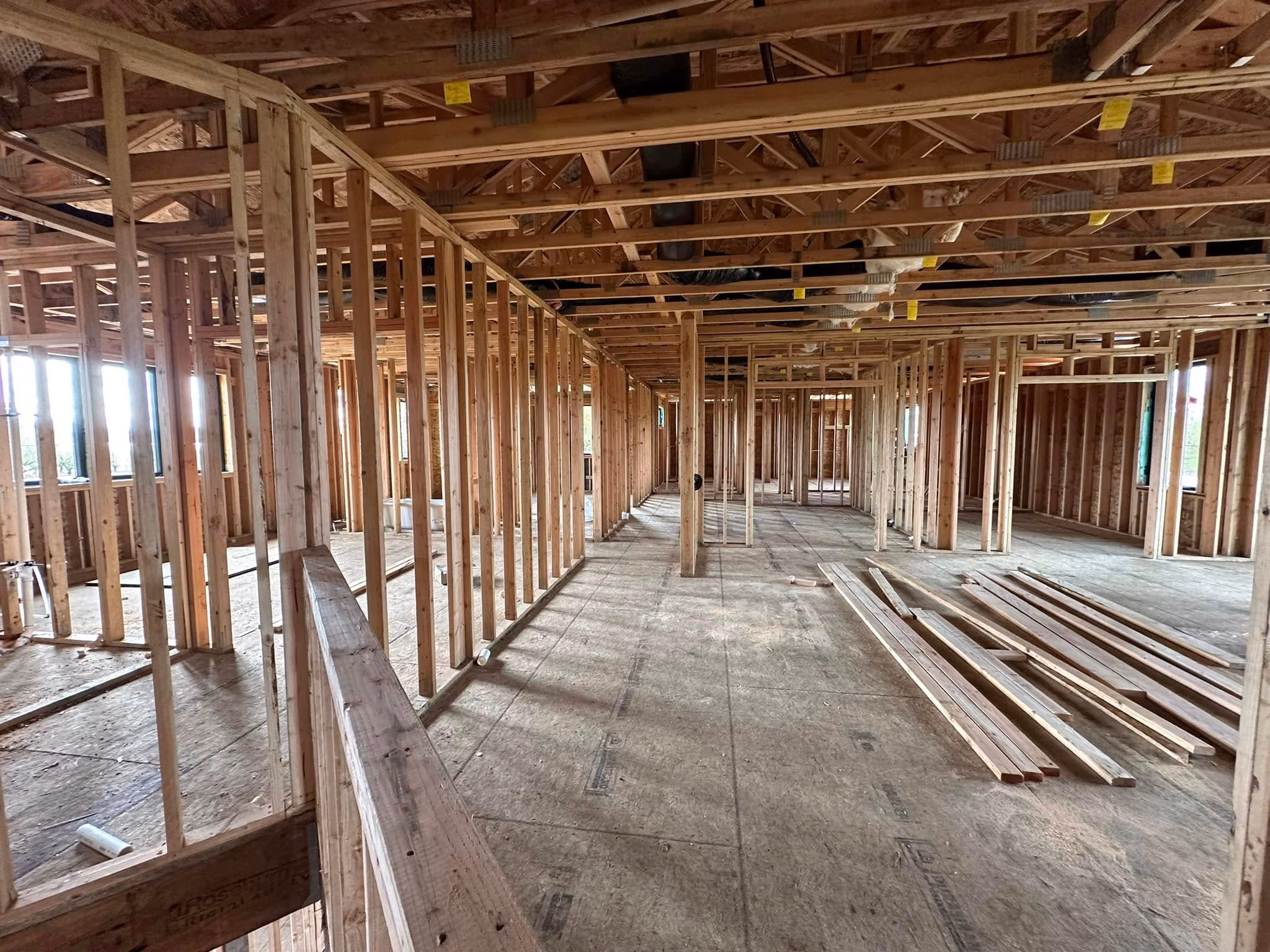 Interior framing of a building under construction showing exposed wooden studs and ceiling beams.